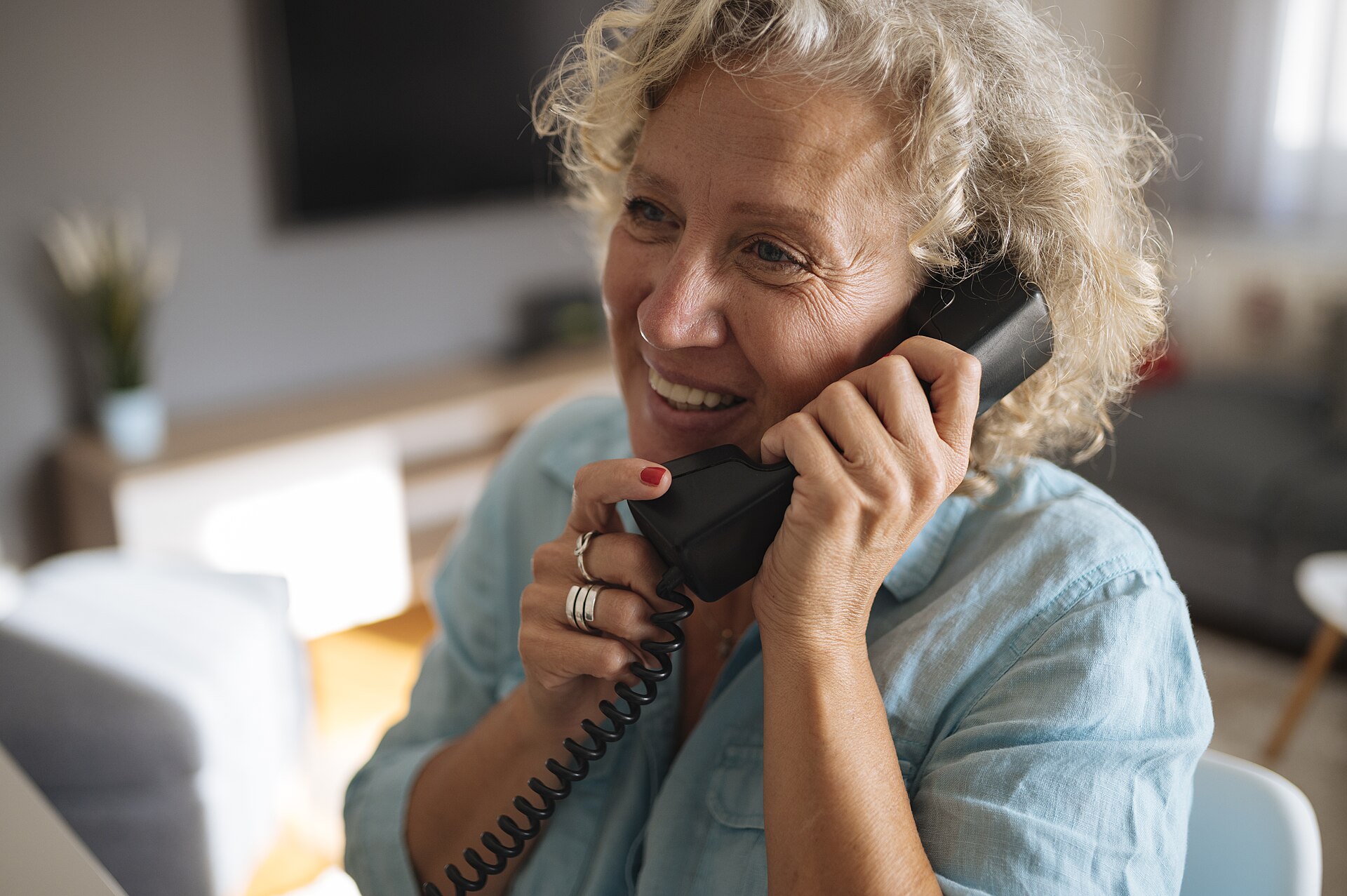 Older adult enjoying a friendly phone conversation at home